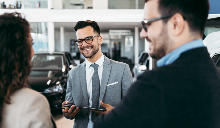 A Salesman talking to customers in a dealership